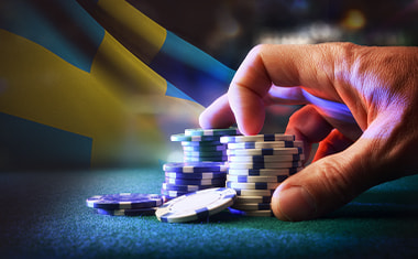 Man som håller i spelmarker och den svenska flaggan